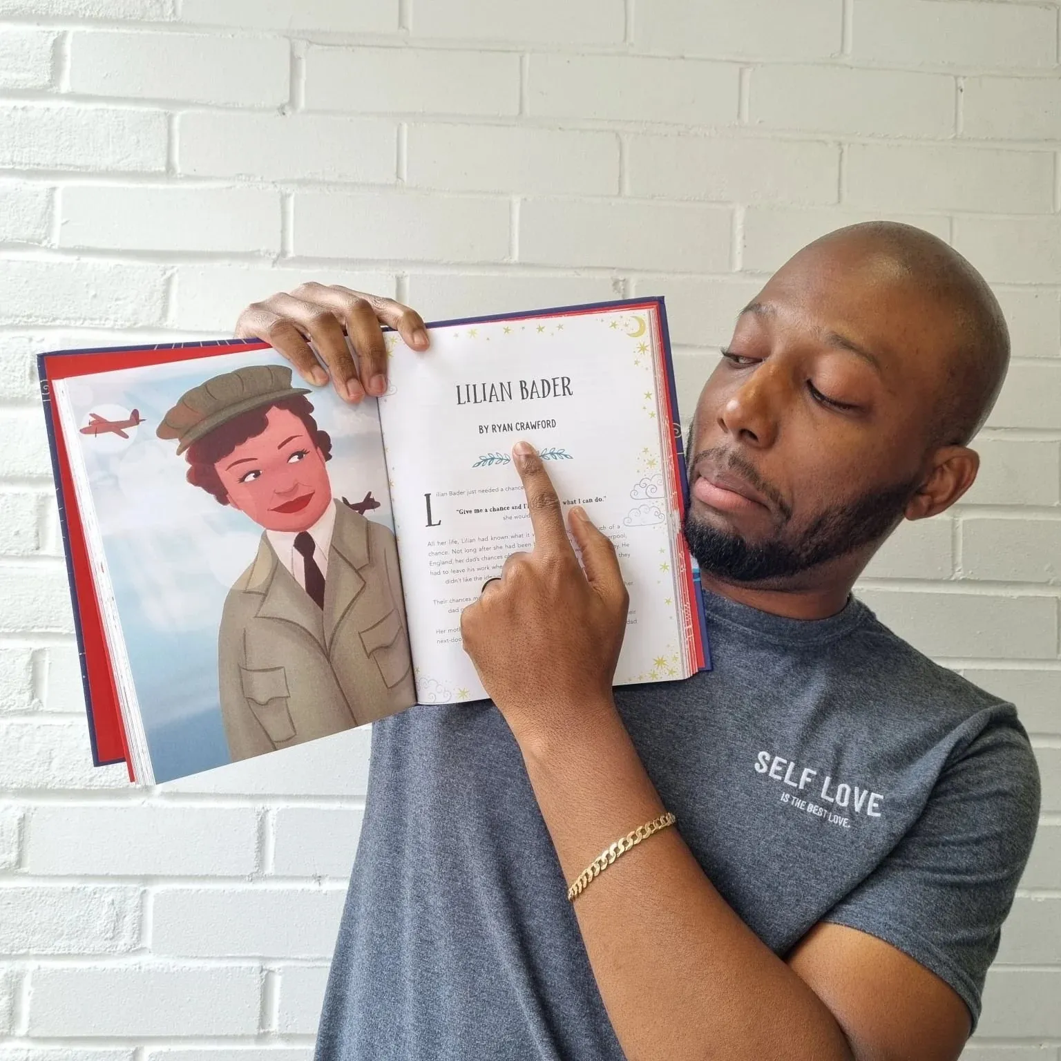 Ryan Crawford holding the book open at the start of the Lilian Bader story