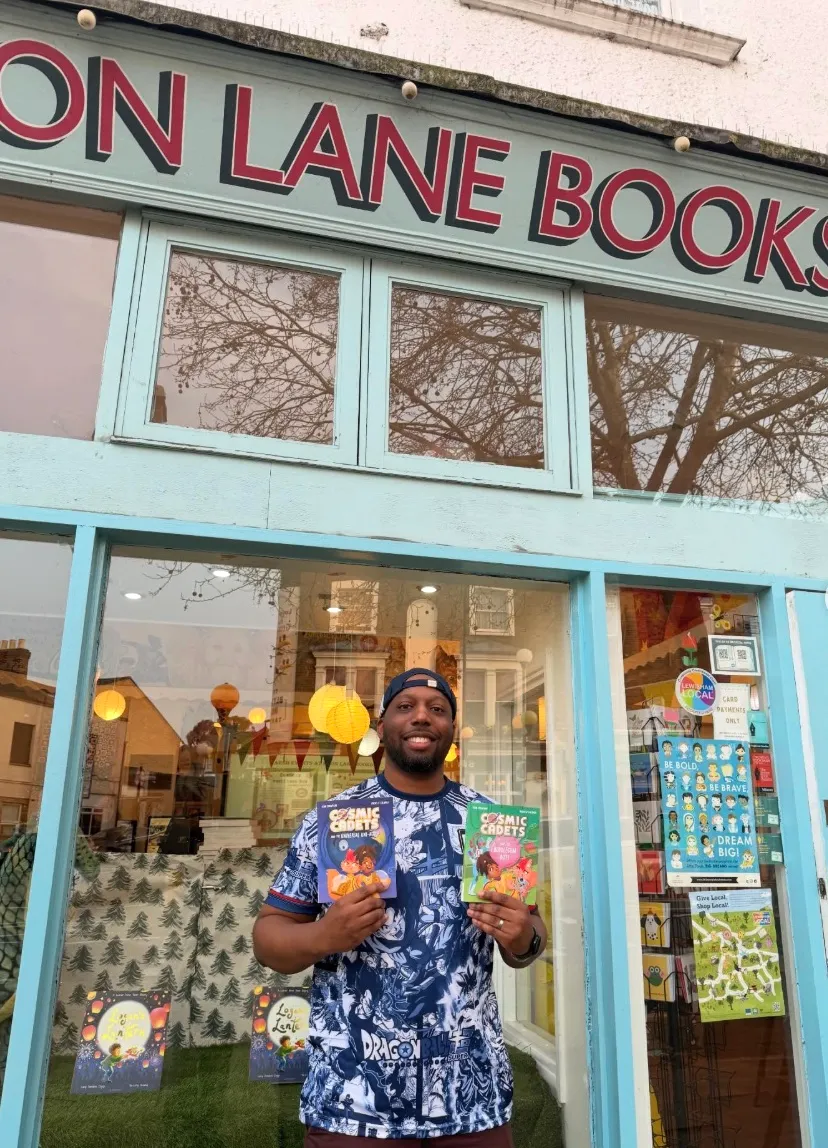 Ryan Crawford outside Moon Lane Books holding both Cosmic Cadets titles