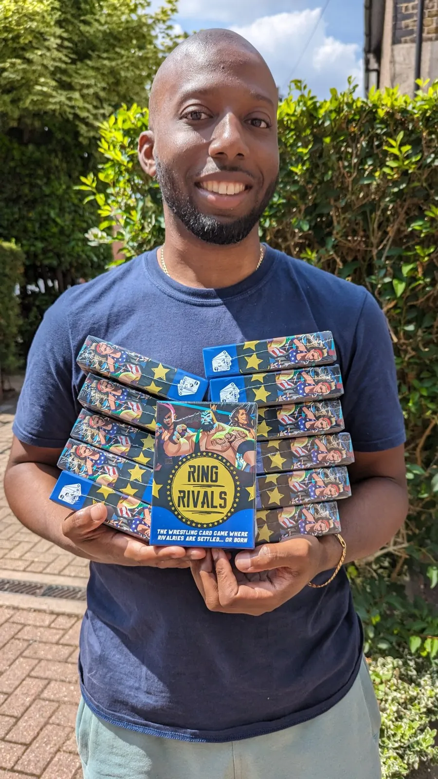 Ryan Crawford holding a stack of Ring Rivals card game boxes