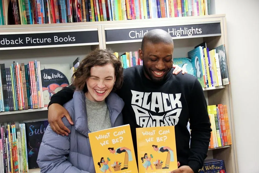 Ryan Crawford and Kayla Coombs in a bookshop, each holding a copy of the book
